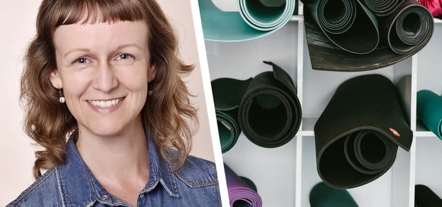 Porträt einer lächelnden Frau mit schulterlangen, gewellten braunen Haaren und kurzem Pony, die eine blaue Jeansjacke trägt. Daneben sind mehrere aufgerollte Yogamatten in verschiedenen Farben in einem weißen Regal zu sehen.