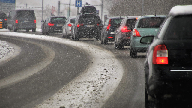 transport-3916275_1920 Autos fahren im Schneefall auf einer verschneiten Straße.