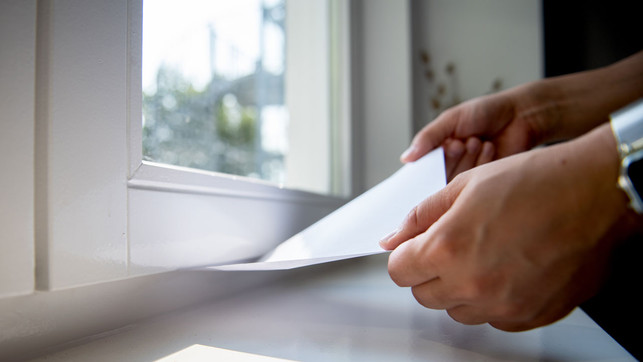 es-zieht-trick-dpa So findet man heraus, ob ein Fenster dicht ist: Ein eingeklemmtes Blatt Papier sollte fest sitzen.