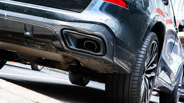 Heckansicht eines schwarzen Autos mit Fokus auf den Auspuff Heckansicht eines schwarzen Autos mit Fokus auf den Auspuff