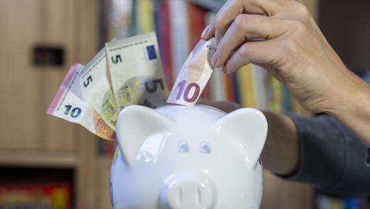 geldscheine-sparschwein-Hendrik-Schmidt-dpa-251229 Geldscheine werden in ein Sparschwein gesteckt