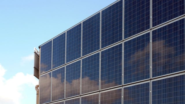 Eine Hauswand ist komplett bedeckt mit Solarmodulen.