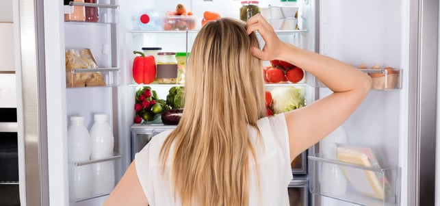 Rear View Of Woman Looking In Fridge Du solltest deinen Kühlschrank regelmäßig abtauen und auch sonst richtig pflegen