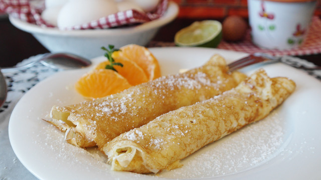 The French pancake is filled and rolled before eating.