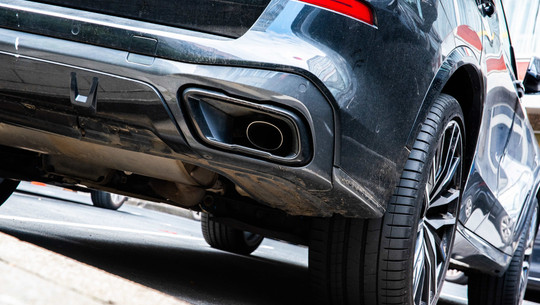 Heckansicht eines schwarzen Autos mit Fokus auf den Auspuff Heckansicht eines schwarzen Autos mit Fokus auf den Auspuff