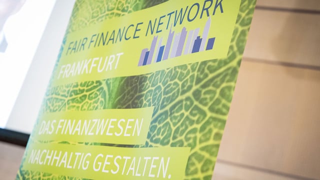FairFinanceWeek_OSC2729_1920x1080px Grünes Banner mit der Aufschrift „Fair Finance Network Frankfurt“ und „Das Finanzwesen nachhaltig gestalten“ vor einem Hintergrund mit Blattstruktur.