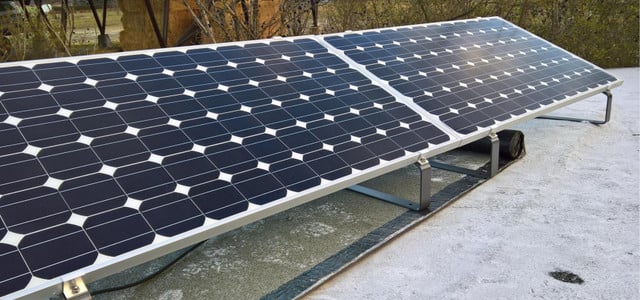 Balkonkraftwerk: Zwei nebeneinander montierte Solarpaneele auf einem flachen, weißen Dach