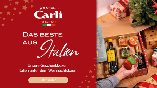 Utopia-Green-Deal-Radar-2025-FratelliCarli-Geschenkebox 1920x1080 Geschenkbox mit italienischen Spezialitäten wie Olivenöl, Pesto Rosso, Pesto Genovese, Tomatensauce und Aceto Balsamico, dekoriert mit Weihnachtsgeschenken und einem Weihnachtsbaum. Text auf rotem Hintergrund: „Fratelli Carli – Das Beste aus Italien – Unsere Geschenkboxen: Italien unter dem Weihnachtsbaum – Jetzt kaufen“.