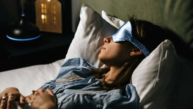 Frau mit Schlafmaske im Bett Frau mit Schlafmaske im Bett