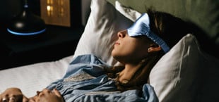 Frau mit Schlafmaske im Bett