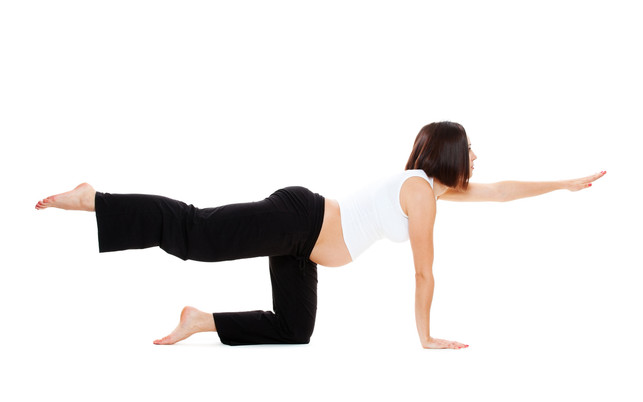 pregnant woman doing yoga exercises Die Diagonale Katze stärkt deinen Rücken.