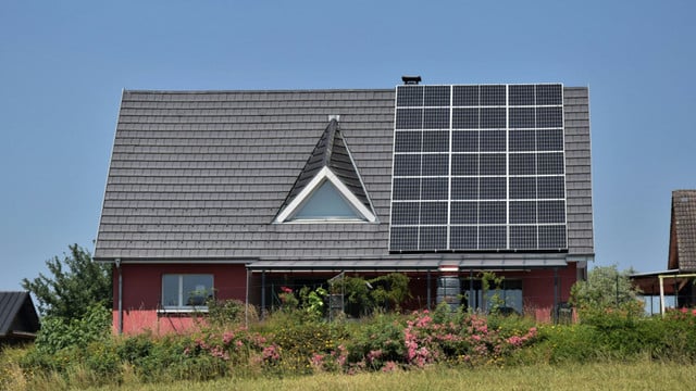 Solarspitzengesetz Einfamilienhaus, auf dem Solarpaneele installiert sind. Der Himmel ist klar und blau.
