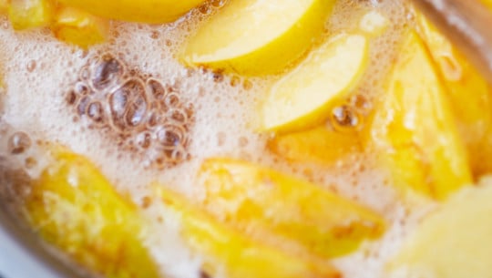 Homemade yello jam, cooking with wooden spoon quittenkompott