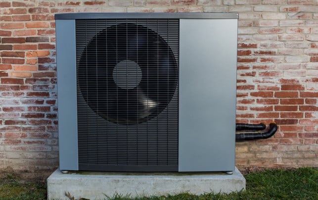 Wärmepumpe reinigen Wärmepumpe vor einer Hauswand