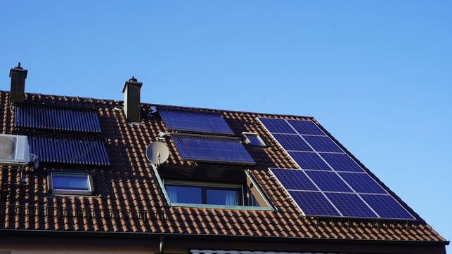 Photovoltaic and solar thermal panels on a residential building roof. Even in winter the sun shines and all units generate energy. The balcony built into the roof invites you to linger. solarthermie alternative gasheizung