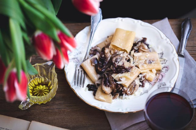 Pasta with radicchio panceta and Parmesan served on a plate on a rustic wooden table Pasta und Radicchio passen sehr gut zusammen.