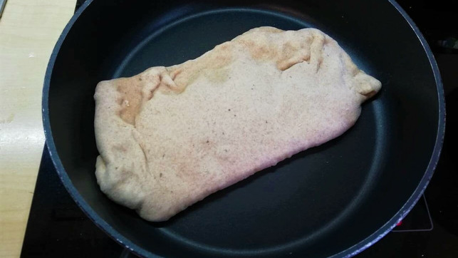 das-gefuellte-naan-wird-in-einer-heissen-pfanne-von-victoria-clauss-utopia-210610 Das gefüllte Naan wird in einer heißen Pfanne von beiden Seiten goldbraun gebacken.