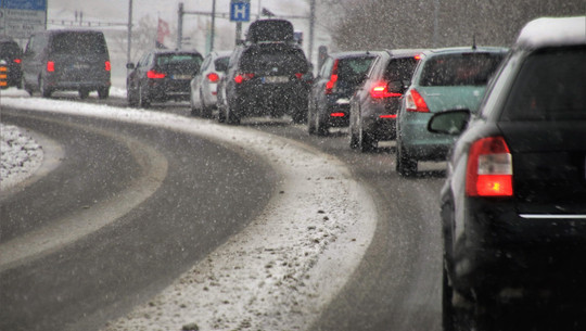 transport-3916275_1920 Autos fahren im Schneefall auf einer verschneiten Straße.