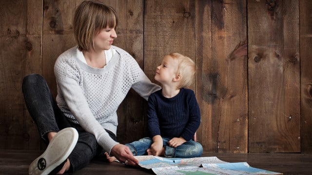 Muttertagsgeschenk, Mutter mit Sohn vor Karte Muttertagsgeschenk, Mutter mit Sohn vor Karte