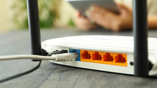 Wi - fi router on gray wooden table, close up router stromverbrauch