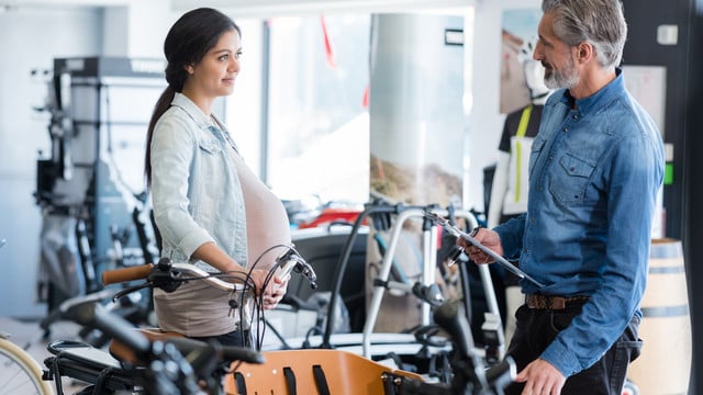 pregnant lady looking at bicycle trailer fahrrad fahren schwangerschaft