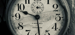 Alte, runde Wanduhr mit großen schwarzen Zahlen auf weißem Zifferblatt, das durch Risse und Flecken gezeichnet ist. Die Uhr zeigt die Zeit 10:29, mit einem kleineren Zifferblatt oben für Sekunden. Auf dem Zifferblatt steht "T. RAM RAO" und "BANGALORE".