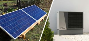 Links zwei auf einem Holzgestell montierte Solarpaneele auf einer Wiese, rechts eine graue Wärmepumpe mit schwarzem Lüftungsgitter vor einer weißen Hauswand