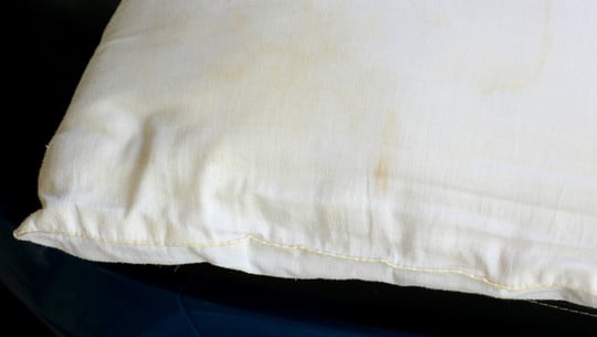 White old pillow with dirty stain. Selective focus gelbe Flecken auf dem Kissen