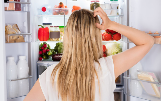 Rear View Of Woman Looking In Fridge Du solltest deinen Kühlschrank regelmäßig abtauen und auch sonst richtig pflegen