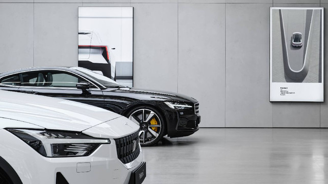 E-Auto Polestar 2 Links Polestar-Autos, rechts am Plakat der Versuch einer Nachhaltigkeitsdeklaration.