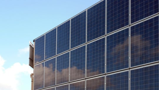 Fassaden-PV: Wann lohnt es sich? Eine Hauswand ist komplett bedeckt mit Solarmodulen.