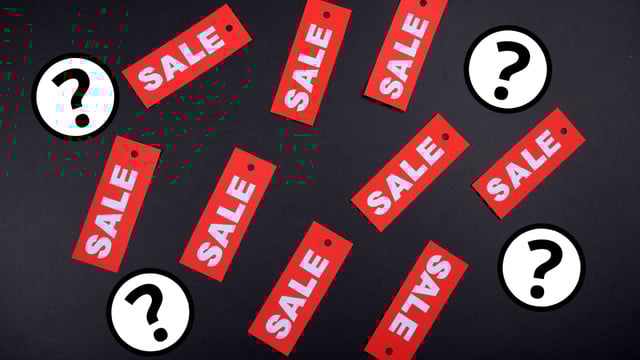 Black Friday: Echte Schnäppchen von Scheinrabatten unterscheiden – so geht's Mehrere rote Preisschilder mit dem weißen Schriftzug „SALE“ liegen verstreut auf einem schwarzen Hintergrund, dazwischen sind weiße Kreise mit schwarzen Fragezeichen.