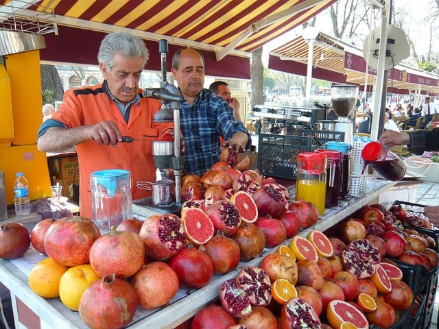 Granatapfelsaftstand Marktstand verkauft Saft vom Granatapfel, von Orangen und anderen Früchten
