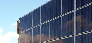 Eine Hauswand ist komplett bedeckt mit Solarmodulen.