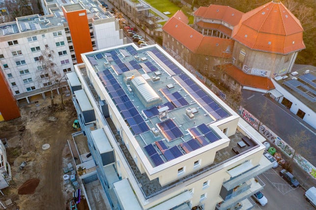 Photovoltaik auf Mehrfamilienhäusern Dach eines modernen Wohngebäudes mit zahlreichen Solarmodulen.
