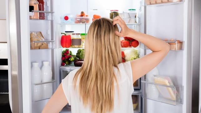 Rear View Of Woman Looking In Fridge Kühlschrank einräumen