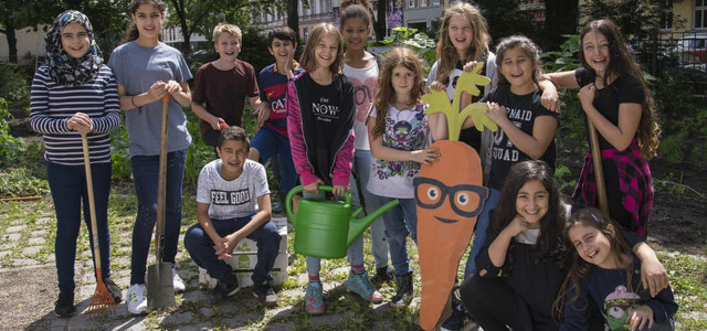 Gruppenbild Kinder der GemüseAckerdemie mit Gartenwerkzeugen