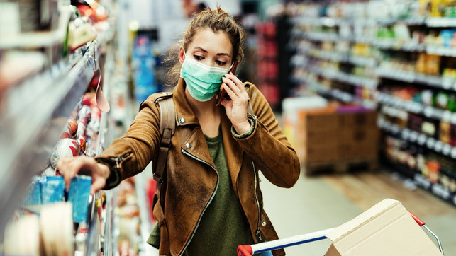 Woman with face mask talking on the phone while shopping in grocery store. Mundschutz, Maske, Aldi, Lidl, dm