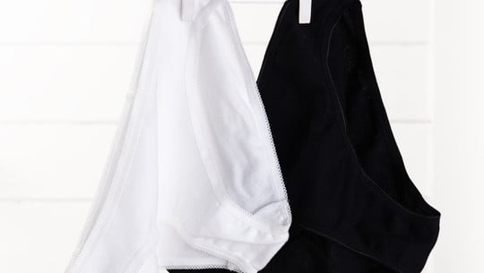 White and black underwear woman dry on rope  over wood backgroun Periodenunterwäsche