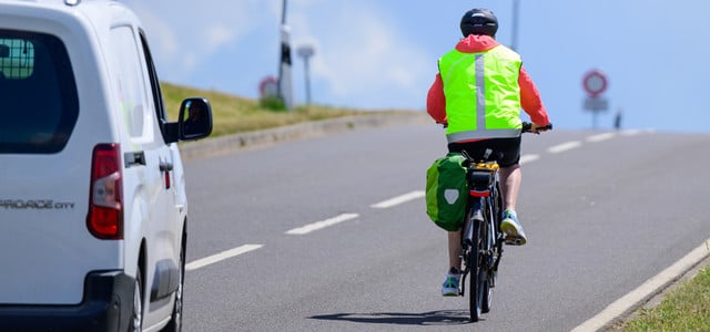 Ein Auto überholt ein Fahrrad