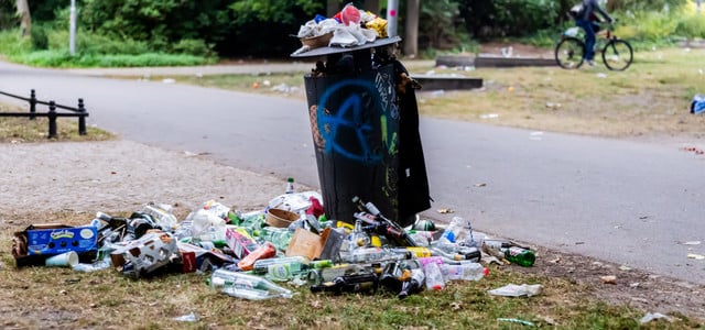 Ein überquellender Mülleimer in einem Park.