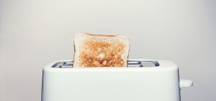 Schütte die Krümel aus, indem du den Toaster kopfüber hälst.
