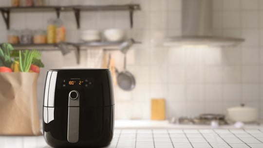 Air fryer machine cooking potato fried in kitchen. Lifestyle of Heissluftfritteusen-Testsieger