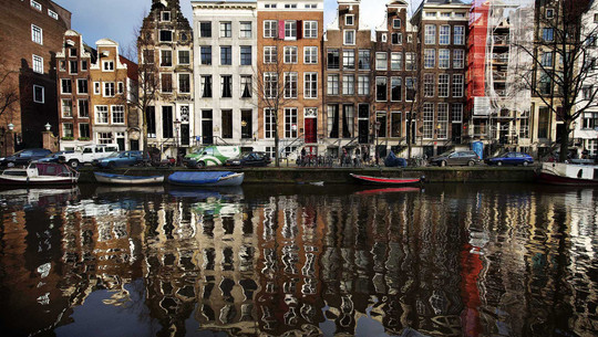 Amsterdam verbietet Reklame für Fleisch und fossile Energien Niederlande, Amsterdam: Häuser an der Herengracht spiegeln sich im Wasser in Amsterdam.