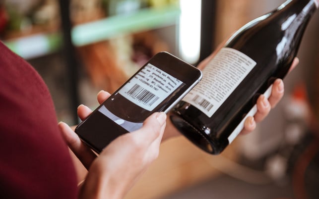 Woman scanning bar code with mobile phone on wine bottle Nicht alle Produkte sind bei Codecheck verfügbar.