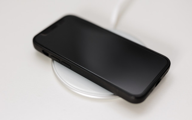Black modern phone lying on white cordless charger Wissenschaftler:innen forschten für fünf Jahre an "Pee Power".