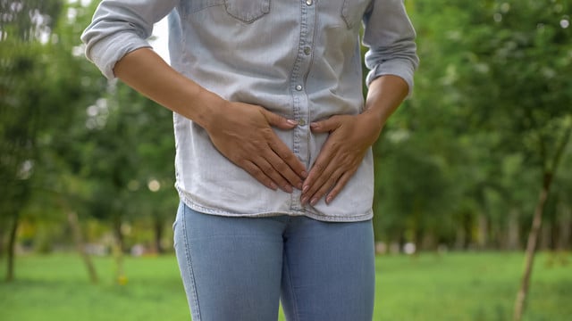 Female in jeans feeling strong lower abdominal pain, menstruation, health care Menstruationsbeschwerden